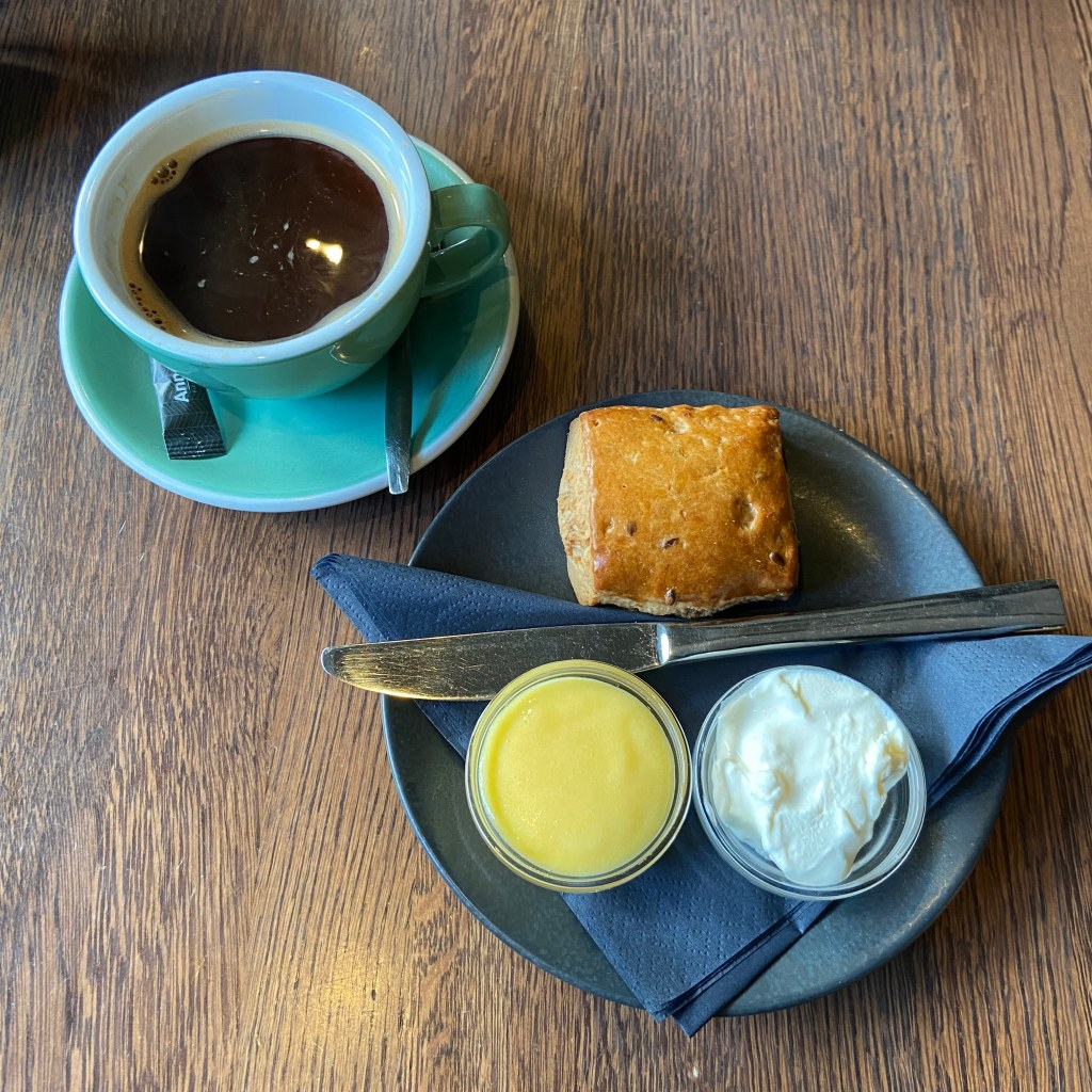 Scone with clotted cream and lemon curd and coffee
